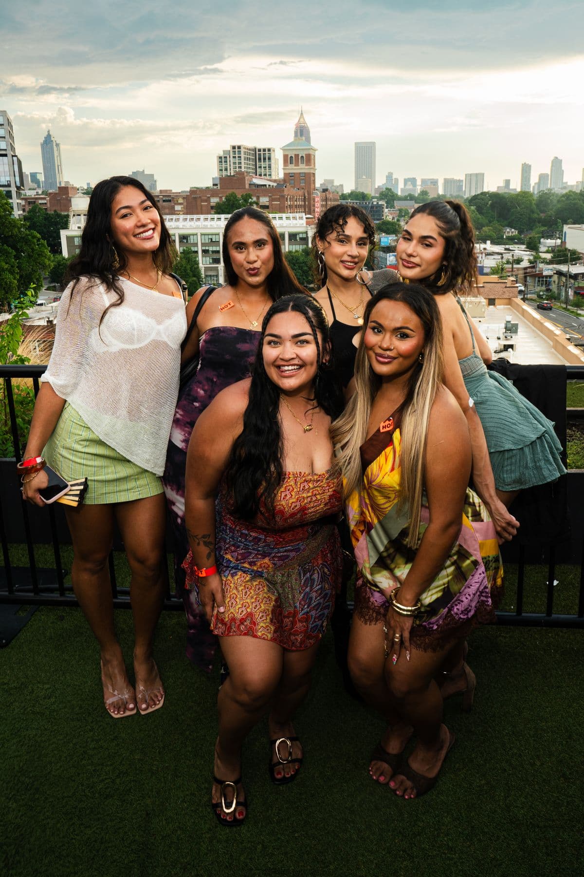 Five friends posing at the rail above the city