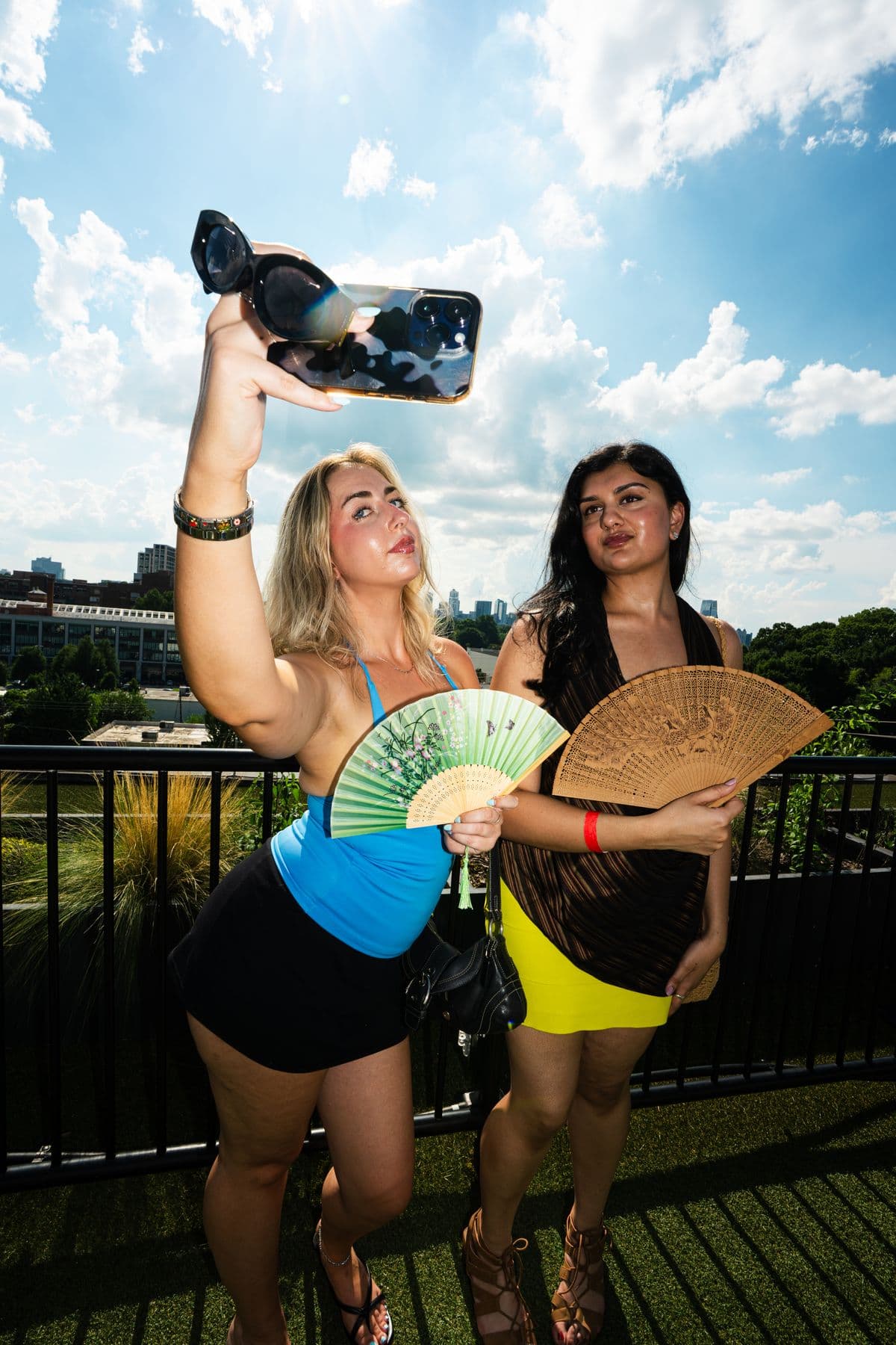 Two dancers waving fans with the Atlanta skyline behind them